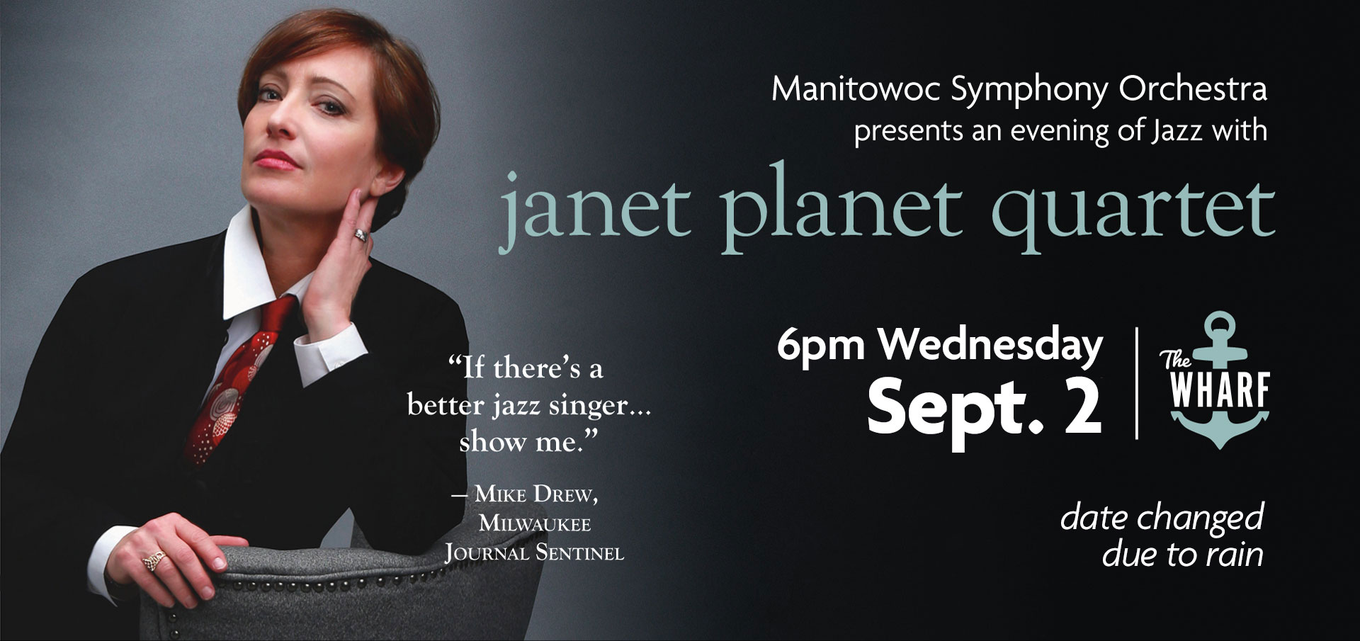 a woman in a black suit and red patterned tie leans on a chair link to janet planet concert information