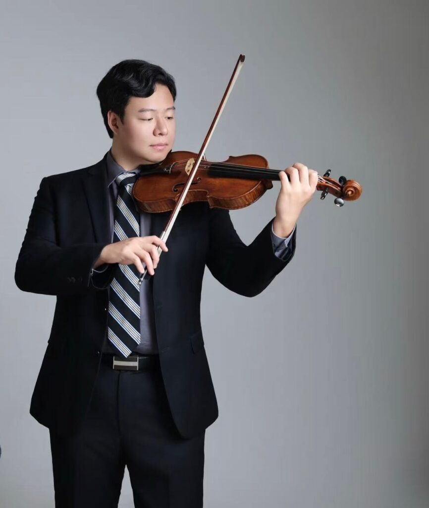 man in suit and tie playing violin