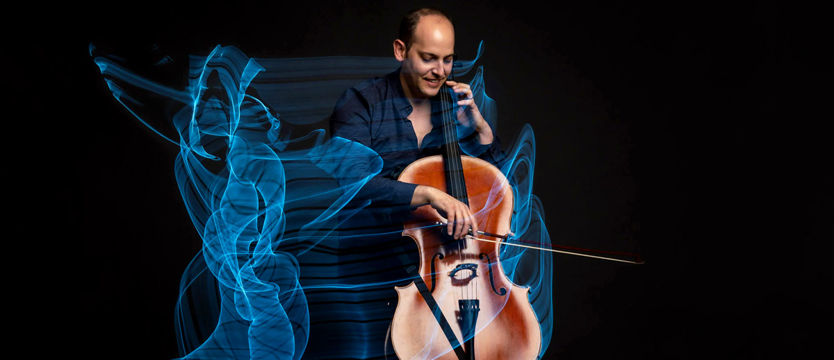 Smiling man plays cello with blue lines of electricity coming from it.