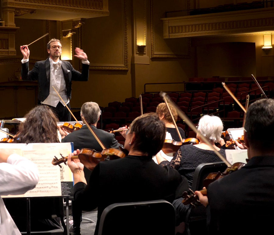 a photo of the orchestra and conductor