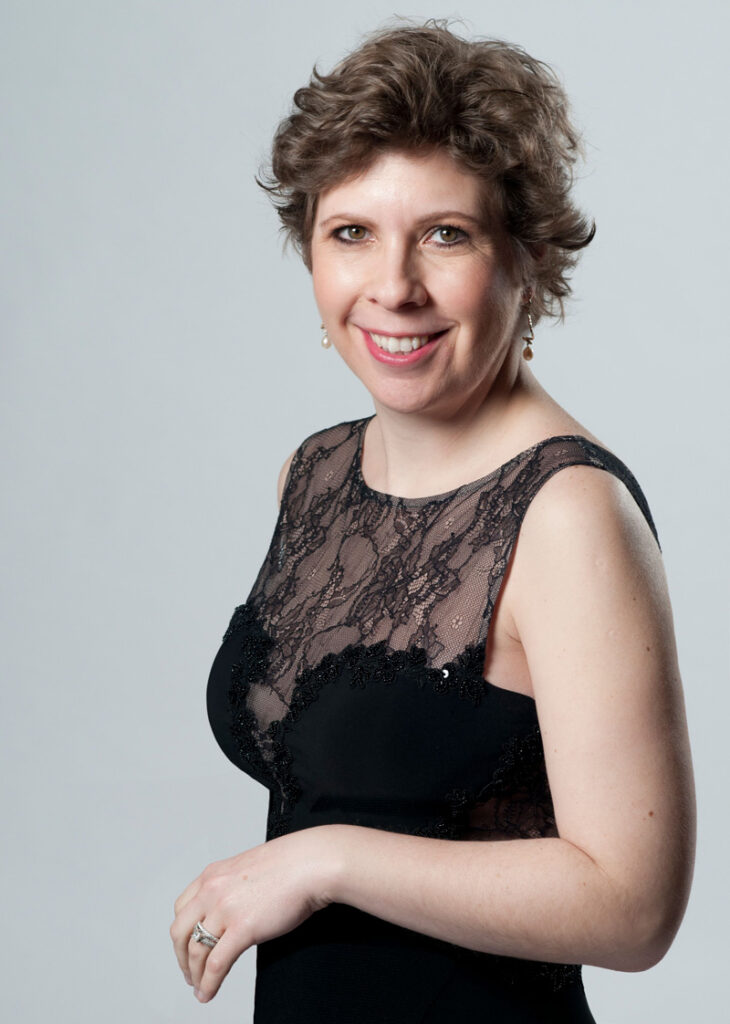 a woman with short light brown hair and a black evening gown